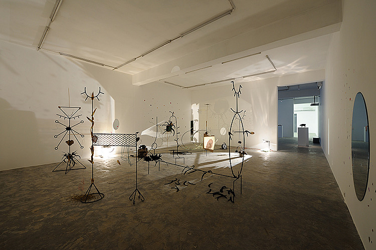 Gallery image: Sedibeng (It Comes With the Rain) | 2017 |  Mixed media installation Steel structures, LED string lights, feathers, printed images, cardboard, large rubber band, flower stickers, healing herbs, slide projection, overhead projector | Presented as part of 'Blind Date', a group exhibition held by Sfeir-Semler Gallery, Beirut  Images courtesy the artist and Sfeir-Semler Gallery 